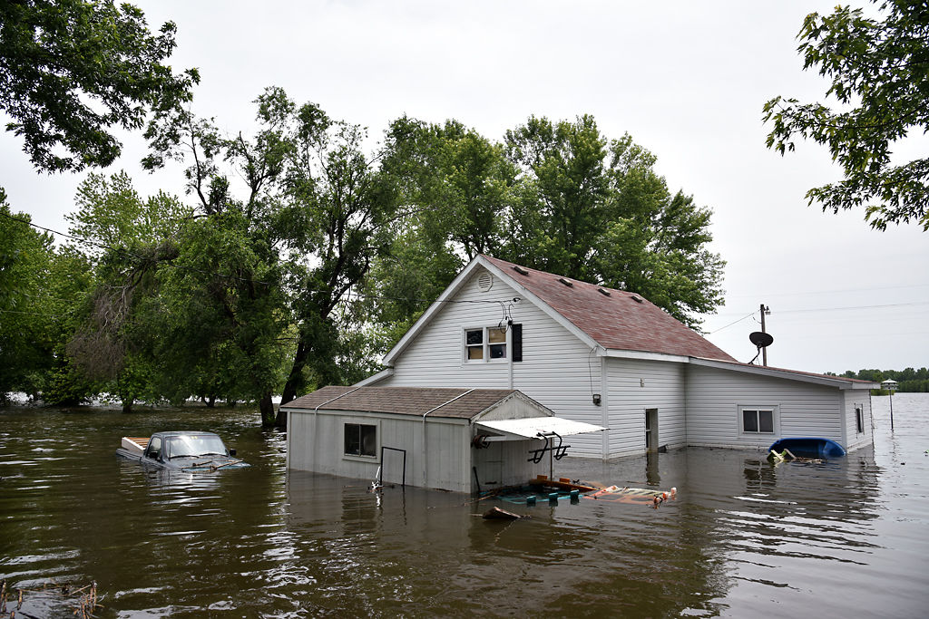 A house and pickup truck are submerged